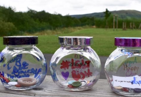 Row of glass jars containing buttons
